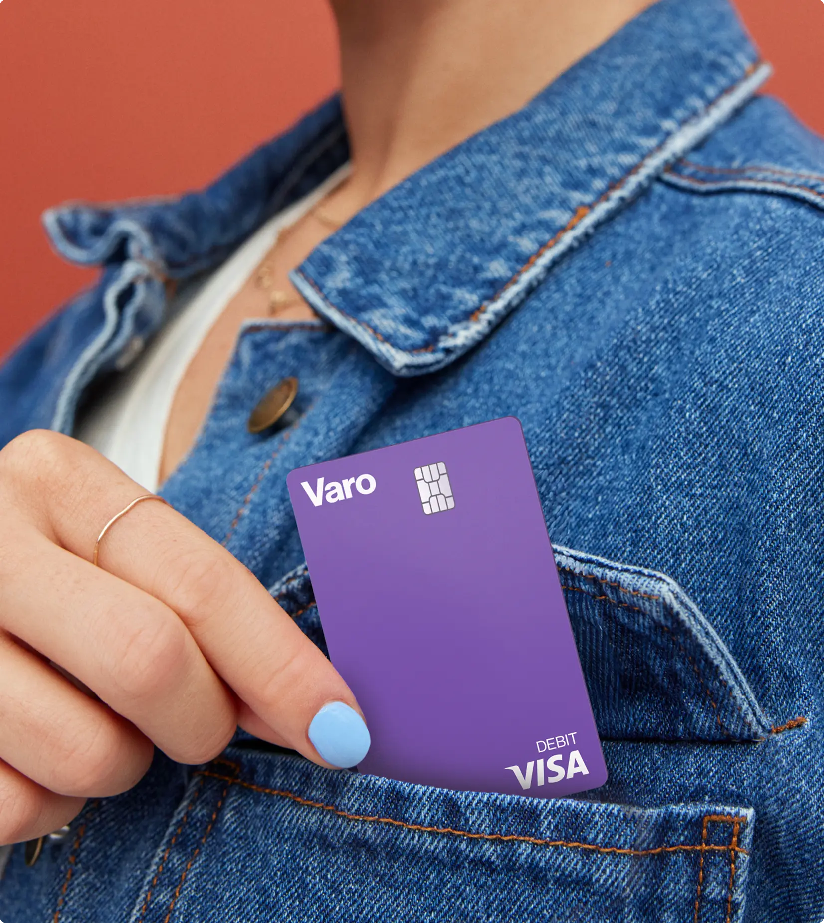 woman putting purple varo debit card into jean jacket pocket no face