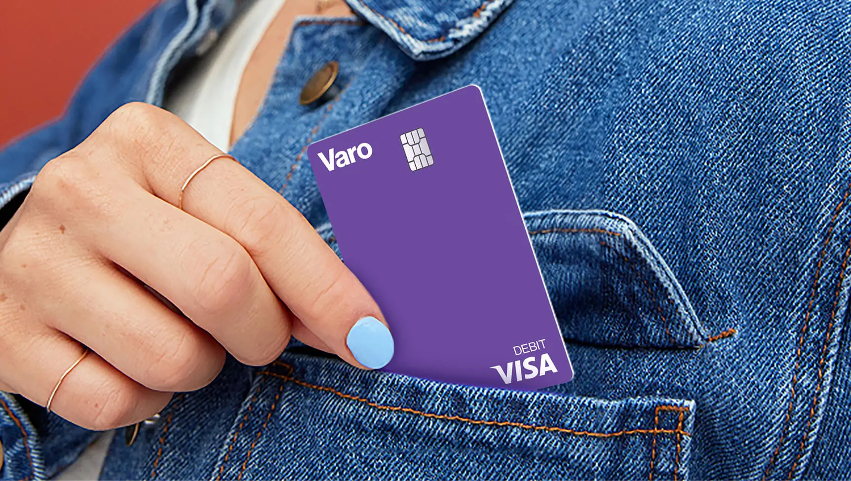 woman putting purple varo debit card into jean jacket pocket no face
